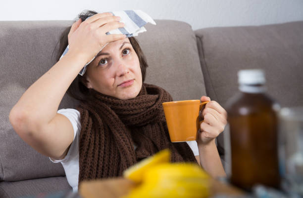 istock Sick woman lying on couch 1219966024