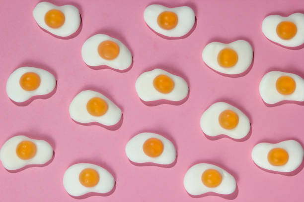 fundo de arte pop. um monte de ovos fritos de marmelada em um fundo pastel rosa. minimalismo comida ainda vida - chilhood - fotografias e filmes do acervo
