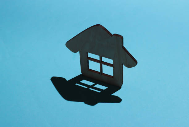 istock Mini house figurine on a blue background with shadow 1219966342