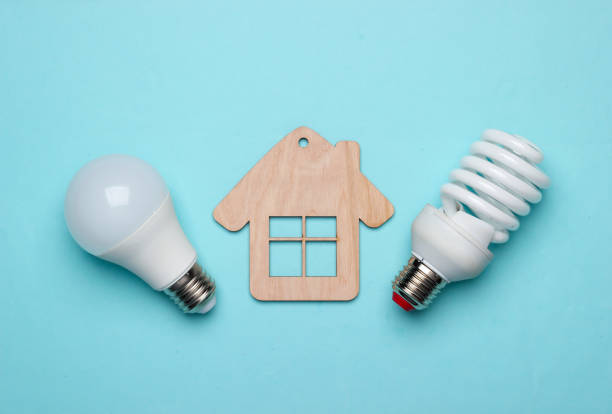 istock Save energy concept. Eco house concept. Mini house and energy-saving light bulb on a blue background 1219967089