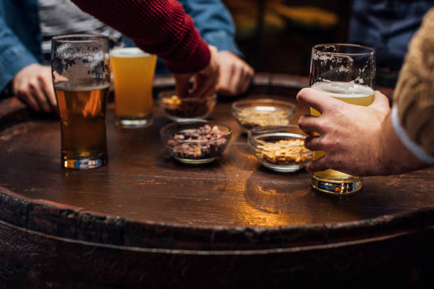 istock Beer and Snacks: Group of Unrecognizable  Men at the Bar Together, a Close Up 1219967616