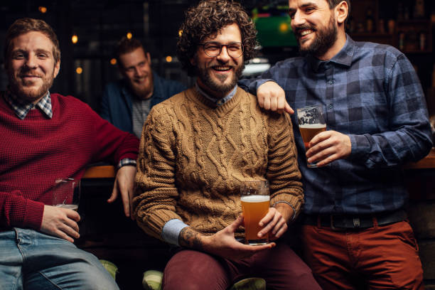istock Happy Group of Men Drinking Beer Together at a Bar 1219967617