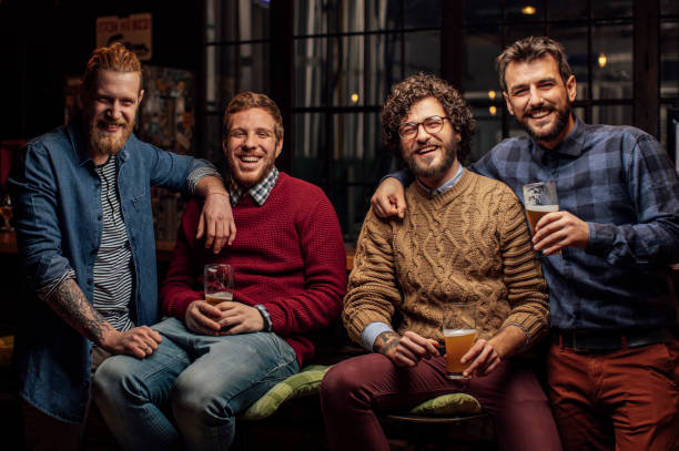 istock Happy Group of Men Drinking Beer Together at a Bar 1219967626