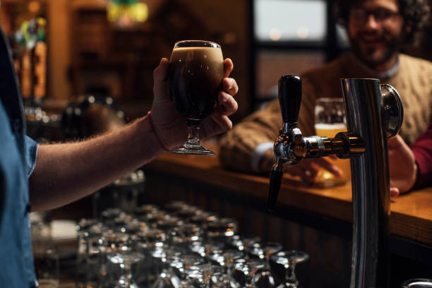 istock Unrecognizable Bartender Serving a Glass of Dark Ale at the Bar 1219967648