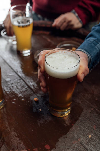istock Hand Holding a Glass of Light Beer 1219967653