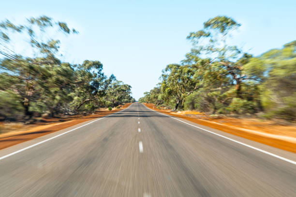 モーションブラーで空のオーストラリアの高速道路。2車線の道路と茂みの低木が赤い砂の上に成長しています。モーション ブラー効果が適用されます。 - highway two lane highway nature western australia ストックフォトと画像