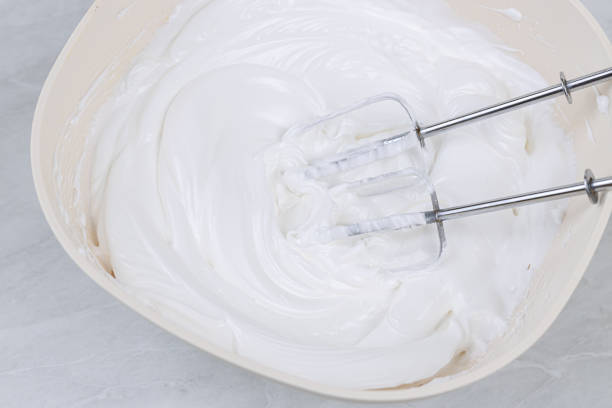 istock White whipped cream in the bowl with mixer above 1219972148