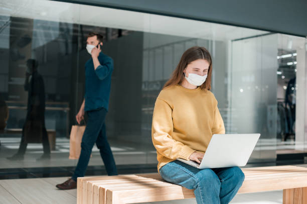 istock young woman using her laptop on the street during quarantine 1219972664