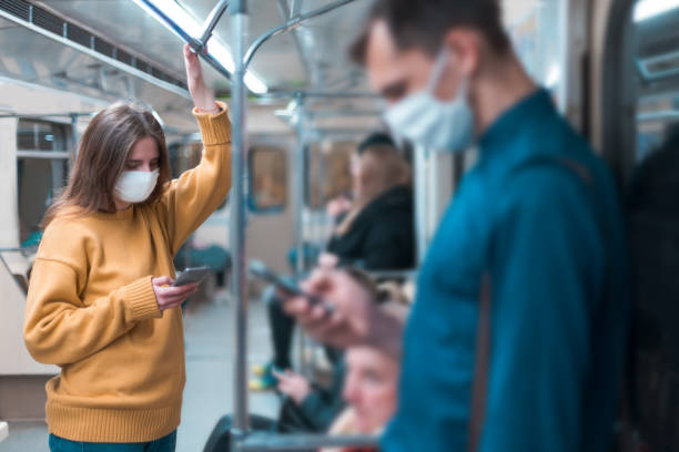 istock young woman in a protective mask standing in a subway car 1219973325