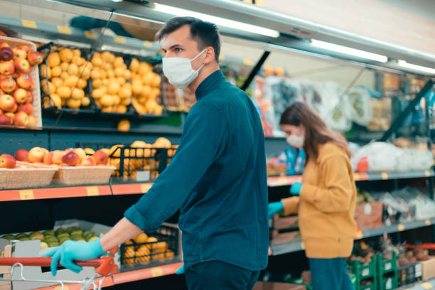 istock shoppers in protective masks choosing fruit in the supermarket 1219973334