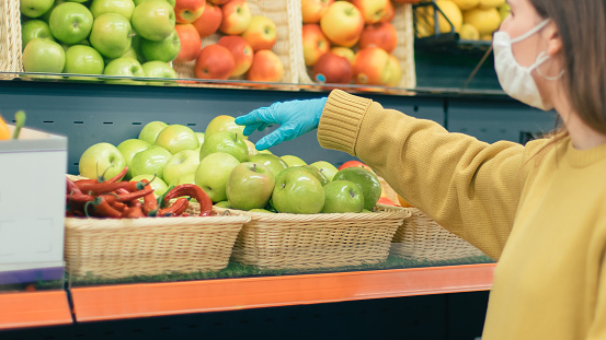 close up. casual woman in protective mask and gloves buying fruit.