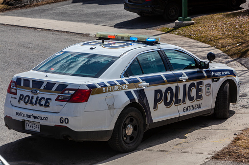 Gatineau, Canada - April 18, 2020: Gatineau police car with emergency lights on the street in times of coronavirus pandemic.