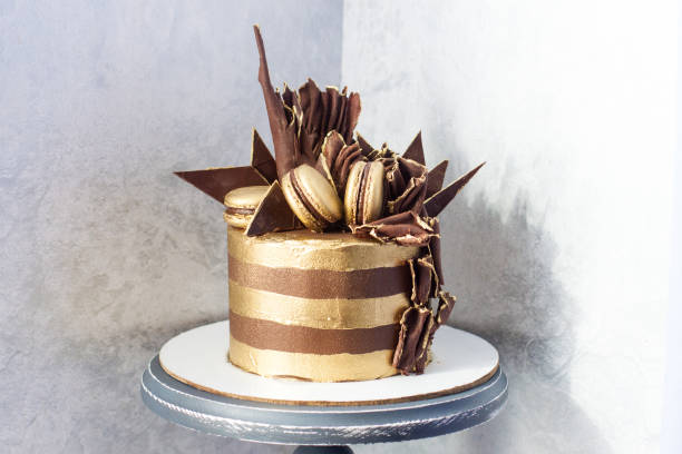 pastel de cumpleaños de chocolate con rayas doradas, decoración de chocolate negro y macarrones. - gateaux cake birthday decorating fotografías e imágenes de stock