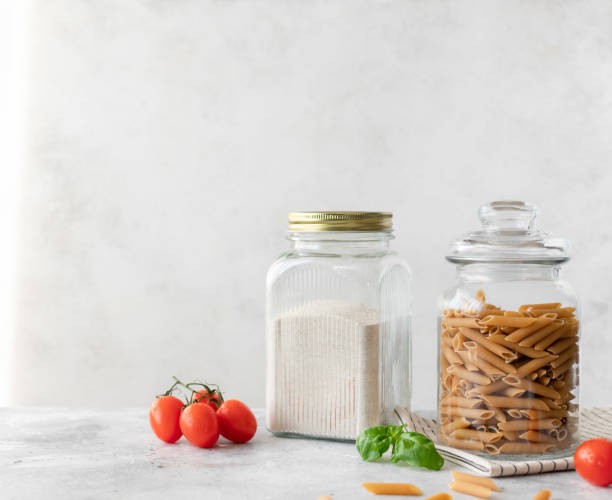 istock glass jars with whole grain flour and whole grain penne pasta. 1219975899
