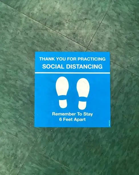 social distancing guideline sticker on the floor of a local business