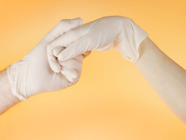 istock Man and woman hands in white protective gloves holding one another 1219982347