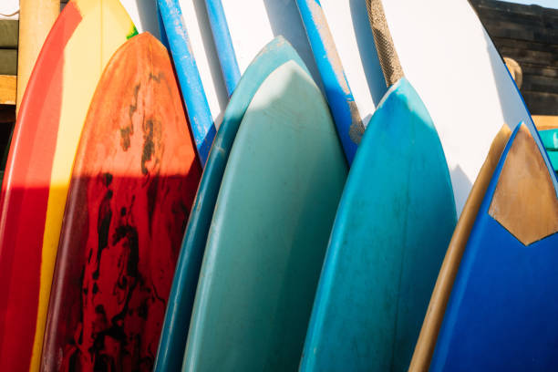istock Set of different color surf boards in a stack by ocean.Bali.Indonesia. Surf boards on sandy beach for rent. Surf lessons on Weligama beach, Sri Lanka. 1219983797