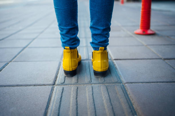 istock Female feet standing on blind pedestrian walking 1219985655
