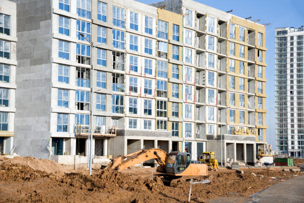 istock Excavator at building under construction. Backhoe digs the ground for the foundation and for laying sewer pipes. 1219987035