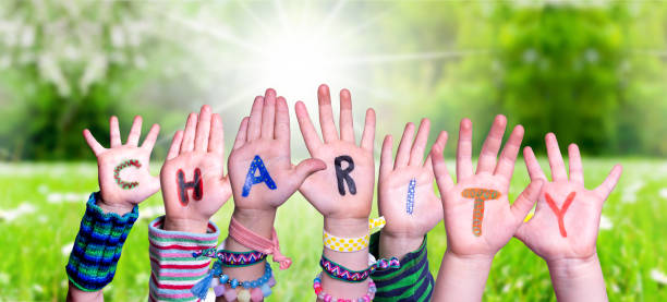 istock Children Hands Building Word Charity, Grass Meadow 1219988302