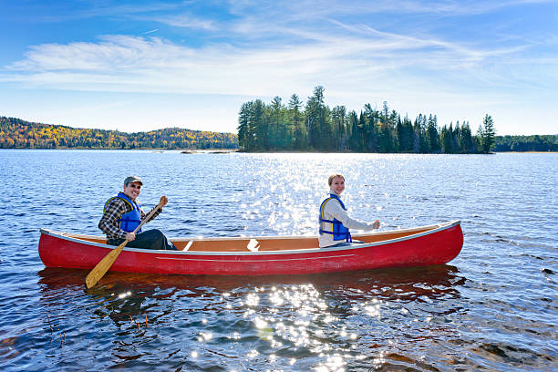 istock Two people in a red canoe on a lake 121998959