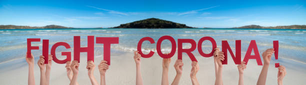 istock People Hands Holding Word Fight Corona, Ocean Background 1219989863