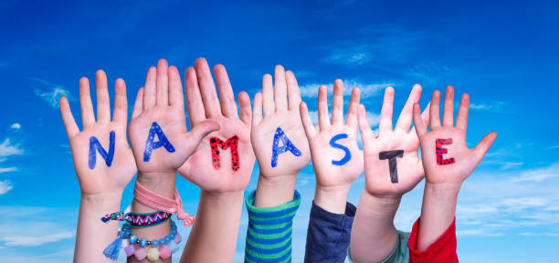 istock Children Hands Building Word Namaste Means Hello, Blue Sky 1219991741