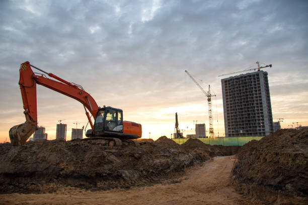 istock Red excavator at building under construction against the background  sunset. 1219992225