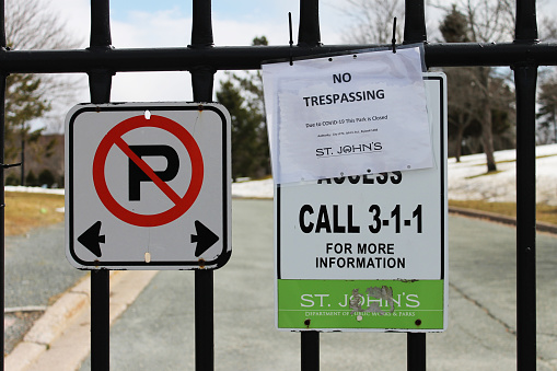 Signs on a park gate announcing that the park is closed due to Covid-19, Bowring Park, St. John's, NL.