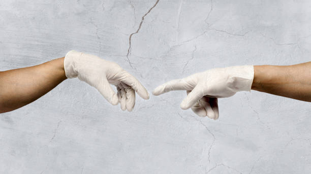 two human hands with surgical gloves, reaching out for each other. the creation of adamo as symbol of protection against covid-19. - michelangelo imagens e fotografias de stock