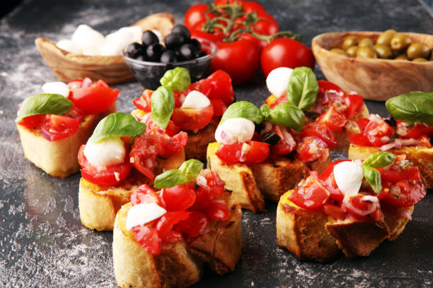 istock Traditional italian bruschetta with cherry tomatoes, cream cheese, basil leaves on rustic background. Italian antipasti mediterranean food 1219994702
