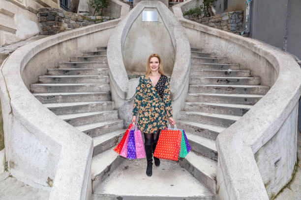 幸せな笑顔でカラフルなショッピングバッグを持っている若い女性。トルコ・イスタンブールのガラタ地区にあるカモンド階段(トルコ語:カモンド・メルディゼンレリ)。 - camondo ストックフォトと画像