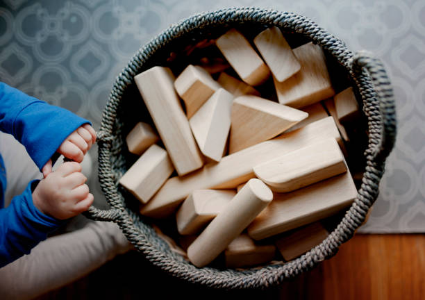 Dziecko ciągnąc kosz niedokończonych drewnianych kształtów bloków – zdjęcie