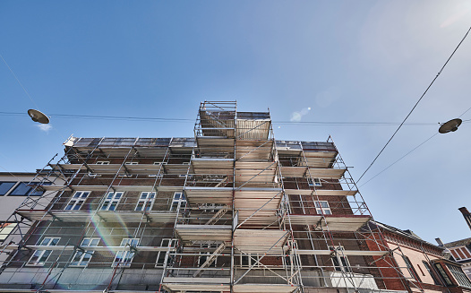 Restoring house in the city. Scaffolding around the building