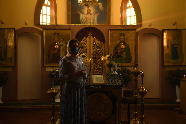 istock Woman in church during pandemic Covid-19. 1219998564