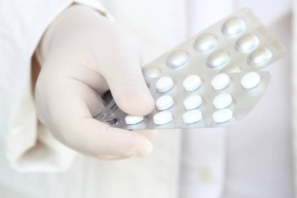 istock Hand in surgical glove holding pill blisters 1219999805
