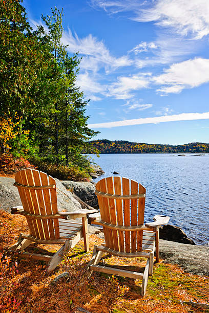 istock Two Adirondack chairs sat close the a beautiful shore line 122000029