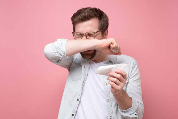istock man with handkerchief and glasses sneezing being ill or having allergy 1220002299