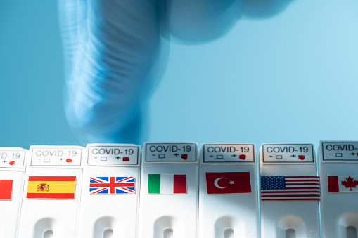 Photo of rapid covid-19 test kit with Italian, Spanish, British, American, Canadian, Turkish and German flags. Possible coronavirus effect on Italy is photographed. Shot with a full frame mirrorless camera.