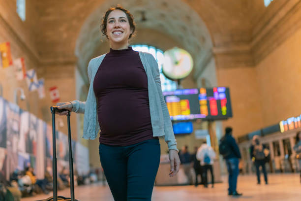 istock Pregnant woman on vacation walking through train station 1220002932