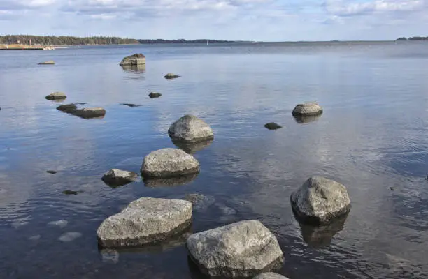 Beach stones in and under blue water, Finland