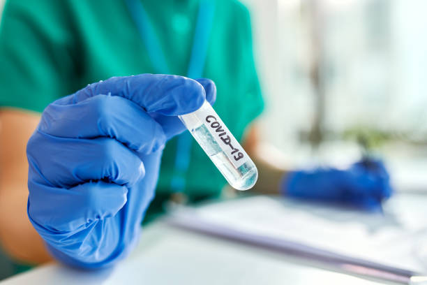 istock Close-up of epidemiologist holding specimen tube with COVID-19 sample. 1220005652