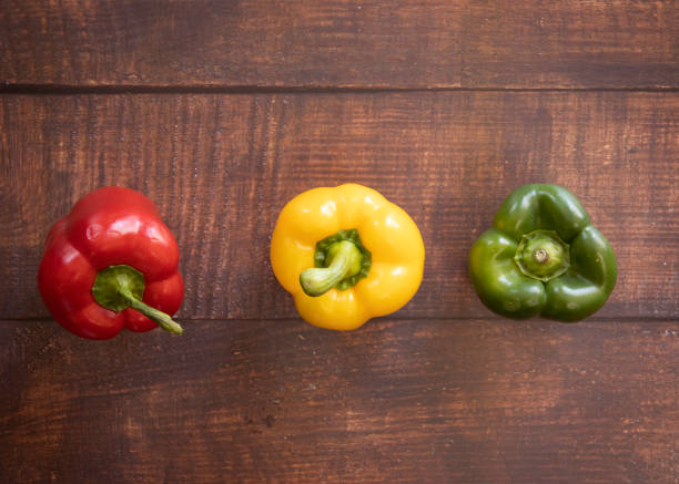 istock Fresh Red, Yellow and Green Bell Pepper on a Brown Wood Plank Background 1220006274