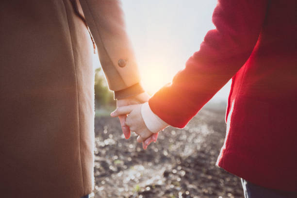 istock mother and child hands abstract sunset shot. Support and protection