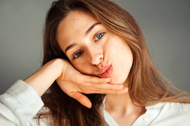 ritratto ravvicinato di una ragazza sorridente con una camicia bianca su sfondo grigio. di buon umore. senza ritocco e trucco. - 2552 foto e immagini stock