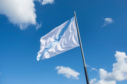 the galician flag waving with the blue sky in the background