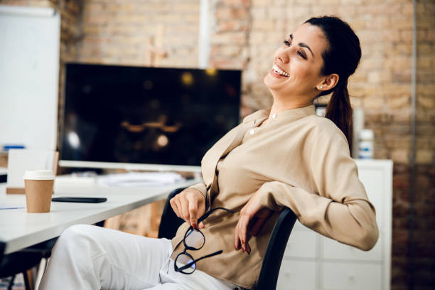 istock Cheerful young woman sitting at the table in office 1220014455