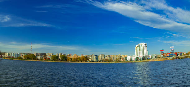 istock Khmelnitskyi / Ukraine - 04.18.2020 Eastern Europe small city waterfront fish eye panoramic photography with river foreground and modern building background curved horizon line summer clear weather 1220014657