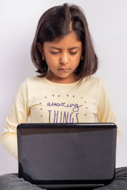istock Cute little girl is using her notebook and headphones 1220017934
