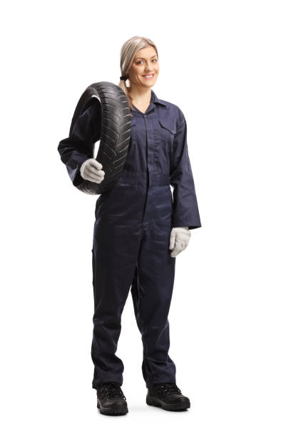 istock Female auto mechanic holding a car tire 1220019477